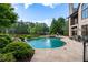 Backyard pool with built-in spa surrounded by lush landscaping and a patio at 938 Crescent River Pass, Suwanee, GA 30024