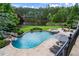 Stunning backyard oasis with a gorgeous in-ground pool, jacuzzi, and lush landscaping near a pond at 938 Crescent River Pass, Suwanee, GA 30024