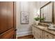 Charming powder room with stylish vanity, granite countertop, and decorative mirror at 938 Crescent River Pass, Suwanee, GA 30024