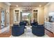 Bright sitting room featuring four blue armchairs, a modern light fixture, and french doors leading to the exterior at 938 Crescent River Pass, Suwanee, GA 30024