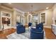 Elegant sitting room with hardwood floors, blue armchairs, and French doors leading to outdoor view at 938 Crescent River Pass, Suwanee, GA 30024