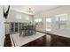 Bright dining area featuring modern light fixture, dark floors, and a view of the backyard and lake at 141 Aylesbury Blvd, Mcdonough, GA 30252