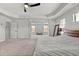 An expansive main bedroom with a tray ceiling, neutral carpet, a seating area, and plenty of natural light at 141 Aylesbury Blvd, Mcdonough, GA 30252