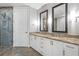 Bathroom featuring dual sinks with granite countertops and a glass shower enclosure at 270 17Th Nw St # 2002, Atlanta, GA 30363