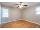 Bedroom features hardwood floors, natural light from two windows, and a ceiling fan at 928 Magna Carta Nw Dr, Atlanta, GA 30318