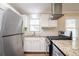 Kitchen with stainless steel appliances, granite countertops, and a modern range hood at 928 Magna Carta Nw Dr, Atlanta, GA 30318