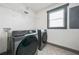 Laundry room showcasing modern washer and dryer units, geometric patterned flooring, and a window at 2357 Lynn Iris Dr, Decatur, GA 30032