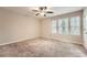 Spacious bedroom with neutral carpeting, ceiling fan, and bright natural light from three windows at 2436 Wilshire Ct, Decatur, GA 30035