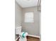 Neutral-toned bathroom with window and matching toilet with teal accent at 346 Henry Aaron Sw Ave, Atlanta, GA 30310