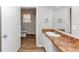 Neutral-toned bathroom with wide mirror, white cabinets and wood-look flooring at 346 Henry Aaron Sw Ave, Atlanta, GA 30310