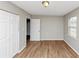 Bedroom with wood-look floors, a window, and white double door closet at 346 Henry Aaron Sw Ave, Atlanta, GA 30310