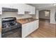 Well-lit kitchen features a black stove and white cabinetry and overlooks the adjacent living area at 346 Henry Aaron Sw Ave, Atlanta, GA 30310