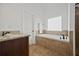 Bathroom showcasing a built-in tub, granite countertops, and a neutral tile floor at 644 Crystal Cove Ct, Loganville, GA 30052
