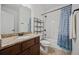 Well-lit bathroom with granite countertops, a shower-tub combo, and patterned shower curtain at 644 Crystal Cove Ct, Loganville, GA 30052
