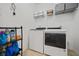 Bright laundry room with washer, dryer, and storage shelves at 644 Crystal Cove Ct, Loganville, GA 30052