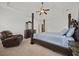 Bright main bedroom with a four-poster bed, ceiling fan, and comfortable recliner at 644 Crystal Cove Ct, Loganville, GA 30052