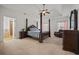 Elegant main bedroom with a four-poster bed, sitting area, and ensuite bathroom at 644 Crystal Cove Ct, Loganville, GA 30052