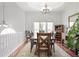 Bright dining room boasts hardwood floors, an elegant chandelier and a large window for natural light at 1772 Ascot Nw Run, Acworth, GA 30102