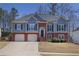 Charming two-story home featuring a brick facade, light blue siding, manicured lawn and attached two-car garage at 1772 Ascot Nw Run, Acworth, GA 30102