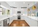 Bright kitchen with stainless steel appliances, farmhouse sink, pendant lights, and wood flooring at 2415 Roxburgh Dr, Roswell, GA 30076