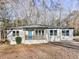 Charming ranch-style home featuring a covered front porch with a bright blue front door at 5205 Silhouette Sw Ln, Mableton, GA 30126