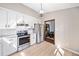 Modern kitchen with stainless steel appliances, granite countertops, and bright white cabinetry at 603 Savannah Way, Woodstock, GA 30189