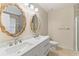 Bright bathroom featuring a double sink vanity, decorative mirrors and tiled floors at 649 Woodcrest Manor Dr, Stone Mountain, GA 30083