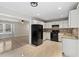 Bright kitchen featuring white cabinetry, stone backsplash, modern appliances, and seamless living room access at 649 Woodcrest Manor Dr, Stone Mountain, GA 30083
