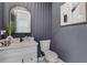 Stylish powder room featuring blue walls, a modern sink, and a sleek arched mirror at 2014 Cambridge Ave, Atlanta, GA 30337