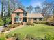 Two story brick home featuring manicured landscaping, and a welcoming walkway leading to the front door at 301 Millbrook Farm Ct, Marietta, GA 30068