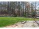 This backyard features a tree-lined perimeter, an expansive lawn, and a brick patio at 326 Bethel Dr, Woodstock, GA 30189