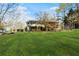 This backyard has mature trees, expansive green grass and a rear deck at 326 Bethel Dr, Woodstock, GA 30189