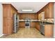 Well-lit kitchen featuring wooden cabinets, tile floors and backsplash, and stainless steel appliances at 326 Bethel Dr, Woodstock, GA 30189