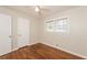A cozy bedroom features hardwood floors, a ceiling fan, and a bright window at 2379 Ridgeway Dr, Atlanta, GA 30360