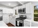 Renovated kitchen with stainless steel appliances, white cabinets, and a bright, sunlit window at 239 Lindbergh Ne Dr, Atlanta, GA 30305
