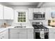 Bright kitchen features white cabinets, stainless steel appliances, and a window over the sink at 239 Lindbergh Ne Dr, Atlanta, GA 30305