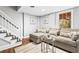Cozy living room with a large sectional sofa, stairs, and light-filled window at 239 Lindbergh Ne Dr, Atlanta, GA 30305