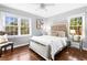 Sun-filled main bedroom featuring hardwood floors, a decorative bed, and large windows at 239 Lindbergh Ne Dr, Atlanta, GA 30305
