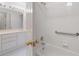 Bathroom featuring a shower and tub combination, with white tile and accessibility bar at 407 Spring House Ne Cv, Atlanta, GA 30307