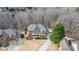 Aerial view of a brick home surrounded by mature trees with a long driveway and manicured landscaping at 6350 Old Wood Hollow Way, Buford, GA 30518