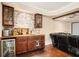 Wet bar with stacked stone backsplash, dark wood cabinets, and a small fridge in the basement living area at 6350 Old Wood Hollow Way, Buford, GA 30518