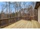 Wooden deck with dark metal railing and a view of the wooded backyard in winter at 6350 Old Wood Hollow Way, Buford, GA 30518