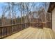 Wide wooden deck perfect for enjoying outdoor scenery in a quiet backyard; wooden railings included for safety at 6350 Old Wood Hollow Way, Buford, GA 30518