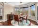 Sunlit dining area showcasing hardwood floors, large windows with wooded views, and elegant furnishings at 6350 Old Wood Hollow Way, Buford, GA 30518