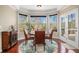 Bright dining area featuring a bay window with views, a stylish rug, and access to the outdoor space at 6350 Old Wood Hollow Way, Buford, GA 30518