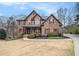 Charming two-story brick home with manicured landscaping and a welcoming covered front porch at 6350 Old Wood Hollow Way, Buford, GA 30518