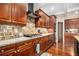 Well-equipped kitchen with wooden cabinets, granite countertops, tile backsplash, and stainless steel appliances at 6350 Old Wood Hollow Way, Buford, GA 30518