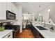 Modern kitchen featuring white cabinets, stainless steel appliances, and an open layout leading to the living area at 1059 Park Row North Se, Atlanta, GA 30312