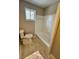 Tiled bathroom featuring a white toilet, tiled shower/tub, and a large window at 4809 Thompson Mill Rd, Lithonia, GA 30058