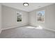 Bright bedroom with neutral walls, plush carpet, recessed light and two windows showcasing green trees at 4809 Thompson Mill Rd, Lithonia, GA 30058